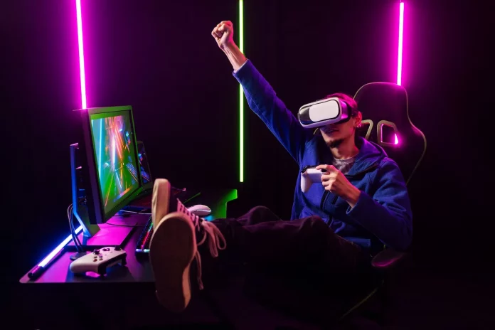 a person wearing virtual reality goggles and sitting in front of a computer
